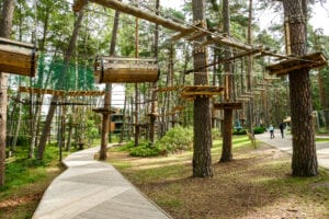 Adventure climbing high wire park people on course in mountain helmet and safety equipment