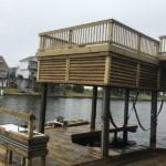 Boat house with dock and deck built with marine treated lumber and square pilings.