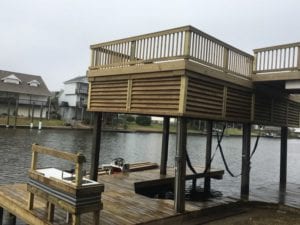 Boat house with dock and deck built with marine treated lumber and square pilings.